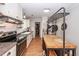Traditional kitchen with white cabinets, stainless steel appliances, and a butcher block island with pot rack at 104 Clover St, Summerville, SC 29483