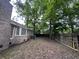 Spacious backyard with privacy fence and mature trees and brick facade of home at 106 Pelican St, Ladson, SC 29456
