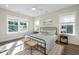 Sunlit bedroom features a metal frame bed, ceiling fan, and windows with neighborhood views at 109 Gray Pine Ln, Summerville, SC 29483