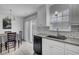 Well-lit kitchen with white cabinets, a granite countertop, stainless steel sink, and gray backsplash at 109 Wisteria Court Ct, Summerville, SC 29486