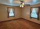 Bright bedroom with neutral carpet, two windows with curtains, and a ceiling fan at 111 Craven Rd, Ladson, SC 29456