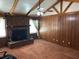 Inviting living room featuring a brick fireplace, wood paneled walls, beamed ceiling, and neutral carpet at 111 Craven Rd, Ladson, SC 29456