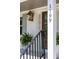 A close-up of the house address, a lantern, a wood front door, plants, and the front porch at 1199 Island View Dr, Mount Pleasant, SC 29464