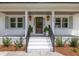 Inviting front porch with classic lanterns, a striking front door, and decorative plantings at 1199 Island View Dr, Mount Pleasant, SC 29464