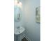 Simple bathroom with pedestal sink, round mirror and modern light fixture at 1202 Twin Rivers Dr, Wando, SC 29492