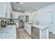 Well-lit kitchen featuring white cabinets, granite counters, and stainless steel appliances at 1202 Twin Rivers Dr, Wando, SC 29492