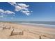 Serene view of the sandy beach and tranquil ocean waters on a sunny day at 128 Palmetto Blvd, Edisto Beach, SC 29438