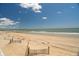 A stunning view of a expansive sandy beach and ocean under a clear blue sky with scattered clouds at 128 Palmetto Blvd, Edisto Beach, SC 29438