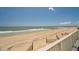 View of a beach and ocean on a clear day with a white railing in the foreground at 128 Palmetto Blvd, Edisto Beach, SC 29438