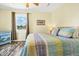 Bright bedroom featuring decorative dresser, wood look floors, and a comfortable-looking bed with a colorful quilt at 128 Palmetto Blvd, Edisto Beach, SC 29438