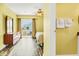 Bright bedroom featuring wood-look floors, yellow walls, dresser, and slider access to the outside deck at 128 Palmetto Blvd, Edisto Beach, SC 29438
