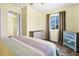This bedroom features wood-look floors, bright, yellow walls, dresser, and a comfortable-looking bed with a colorful quilt at 128 Palmetto Blvd, Edisto Beach, SC 29438