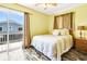This bedroom features wood-look floors, bright, yellow walls, dresser, and slider access to the outside deck at 128 Palmetto Blvd, Edisto Beach, SC 29438