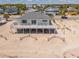 Exterior aerial view of a beach house with a large deck and multiple chairs at 128 Palmetto Blvd, Edisto Beach, SC 29438