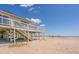 Stilt home on beach with wooden deck, offering stunning ocean views and beach access at 128 Palmetto Blvd, Edisto Beach, SC 29438
