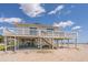 Charming beachfront home on stilts, featuring a spacious deck overlooking the ocean at 128 Palmetto Blvd, Edisto Beach, SC 29438