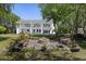 Expansive backyard featuring a fire pit, lush greenery, and a stunning view of the elegant two-story home at 1391 Royston Rd, Mount Pleasant, SC 29464