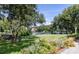 Beautiful landscaped backyard with lush green grass, mature trees, colorful flowers, and a tranquil lake view at 1391 Royston Rd, Mount Pleasant, SC 29464