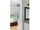 View of the bedroom with hardwood floors, ceiling fan, and bathroom with large mirror in the background at 1391 Royston Rd, Mount Pleasant, SC 29464