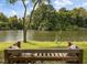 Scenic lake view from a wooden bench with accent pillows and green grass at 1391 Royston Rd, Mount Pleasant, SC 29464