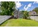 Large backyard with a white fence, patio, and mature trees, perfect for outdoor activities at 1418 Whispering Oak Trl, Mount Pleasant, SC 29466
