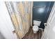 Clean bathroom with decorative shower curtain, white toilet and vanity, with a dark blue accent wall at 1418 Whispering Oak Trl, Mount Pleasant, SC 29466