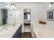 Bright bathroom featuring a dual sink vanity, soaking tub and an open doorway to the Primary bedroom at 1418 Whispering Oak Trl, Mount Pleasant, SC 29466
