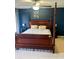 Bedroom with blue walls features a four-poster bed, ceiling fan, and carpet flooring at 1418 Whispering Oak Trl, Mount Pleasant, SC 29466