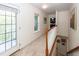 Bright hallway with a door to the balcony and staircase with decorative artwork hanging on the wall at 1418 Whispering Oak Trl, Mount Pleasant, SC 29466