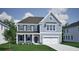 Charming two-story home with a modern color palette, black shutters, and a two-car garage on a sunny day at 142 Seaton St, Summerville, SC 29486