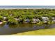 Scenic aerial shot showcasing waterfront homes with backyard pools along a serene lagoon, with lush greenery and ocean views at 15 Edgewater Aly, Isle of Palms, SC 29451