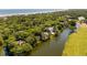 Panoramic aerial view of stunning homes nestled among lush trees, bordering a tranquil lake and golf course at 15 Edgewater Aly, Isle of Palms, SC 29451