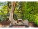 Relaxing backyard space featuring Adirondack chairs around a fire pit surrounded by lush foliage at 15 Edgewater Aly, Isle of Palms, SC 29451