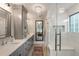 Long bathroom vanity with double sinks, a glass shower with a built in bench, and a mirror at 15 Edgewater Aly, Isle of Palms, SC 29451