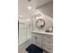 Well-lit bathroom with a modern vanity, round mirror, and a glass-enclosed shower at 15 Edgewater Aly, Isle of Palms, SC 29451