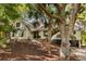 Charming home with a manicured lawn, wooden signage, and lush trees providing privacy with space for parking at 15 Edgewater Aly, Isle of Palms, SC 29451