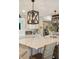 Bright kitchen features a quartz island, decorative hanging lights, and barstool seating at 15 Edgewater Aly, Isle of Palms, SC 29451