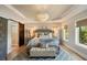 Well-lit main bedroom boasts tray ceilings, a chandelier, an accent rug, and an ensuite bathroom at 15 Edgewater Aly, Isle of Palms, SC 29451