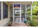 View of the screened porch entrance from the backyard, with a stained glass accent and lush greenery around the deck at 1578 Harborsun Dr, Charleston, SC 29412