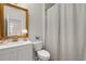 Bright bathroom with a white vanity, a gold trimmed mirror, and a shower with a striped curtain at 160 Cherry Grove Dr, Summerville, SC 29483