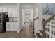 Hallway with stylish decor, leading to the front door, featuring white cabinets and dark wood flooring at 160 Cherry Grove Dr, Summerville, SC 29483