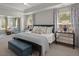 Bright main bedroom with a ceiling fan, tray ceilings, bench seating, and two nightstands at 160 Cherry Grove Dr, Summerville, SC 29483