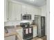Modern kitchen featuring stainless steel appliances, granite countertops, and white cabinetry at 1600 Long Grove Drive # 811, Mount Pleasant, SC 29464