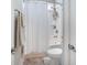 Clean bathroom featuring a shower with white floral curtains, toilet, and a neutral colored accent rug at 169 Callibluff Dr, Summerville, SC 29486