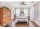 Cozy bedroom featuring hardwood floors, a metal frame bed, and natural light streaming through sheer curtains at 169 Callibluff Dr, Summerville, SC 29486