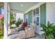 Cozy front porch features wicker chairs, colorful pillows, and green accents, perfect for relaxation at 169 Callibluff Dr, Summerville, SC 29486