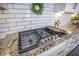 Modern gas cooktop with white subway tile backsplash and granite countertops in a well-appointed kitchen at 169 Callibluff Dr, Summerville, SC 29486