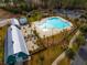 Aerial shot displaying a spacious outdoor pool with swimming lanes, a area, tables and chairs, and ample parking at 169 Callibluff Dr, Summerville, SC 29486