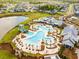 An aerial view of a community pool with a slide, ample seating, and a clubhouse nestled in a picturesque neighborhood at 169 Callibluff Dr, Summerville, SC 29486