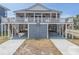 Exterior of beach house on stilts with gray siding and gray garage door at 1701 A Palmetto Blvd, Edisto Island, SC 29438